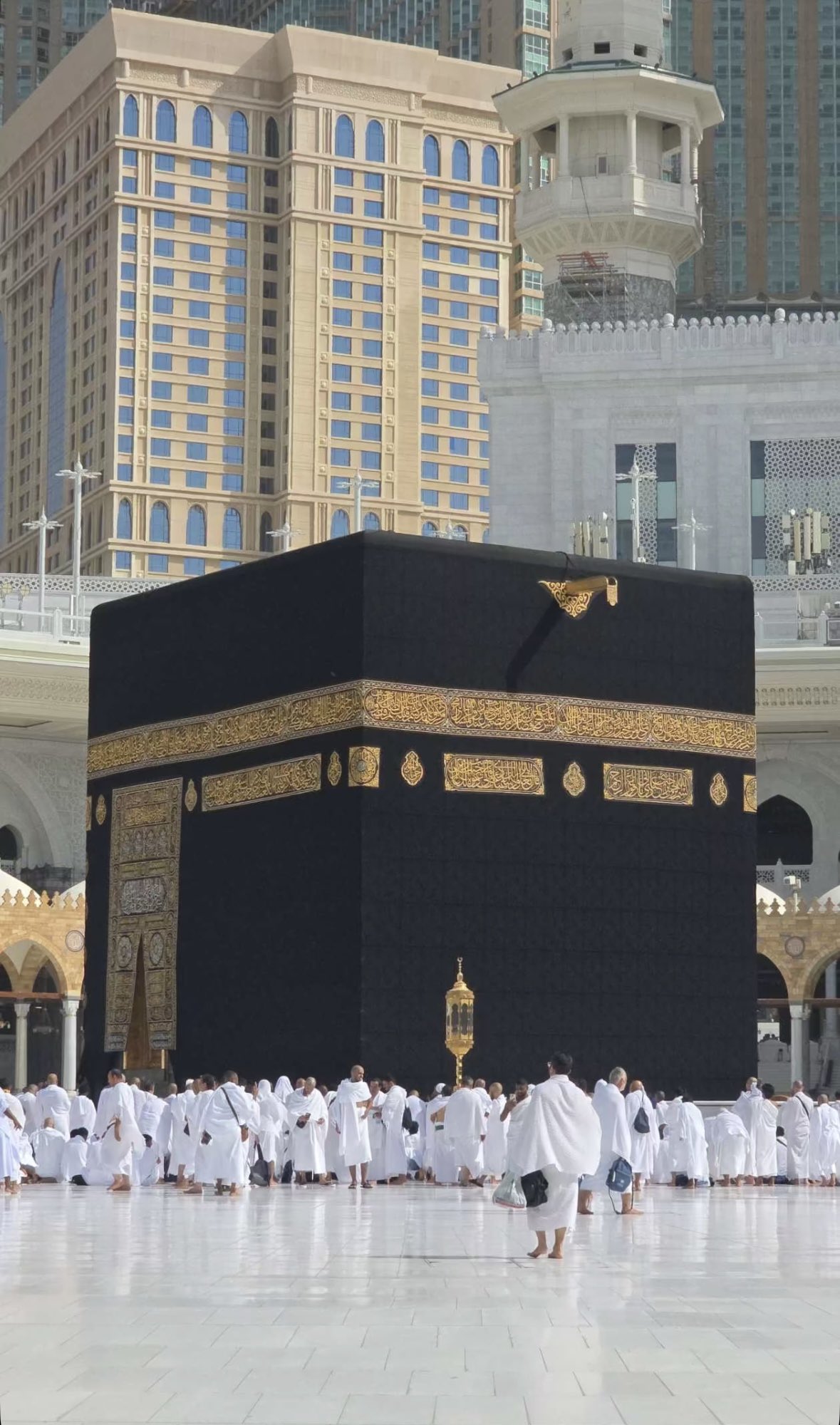Vue rapprochée de la Kaaba avec des pèlerins, de jour.